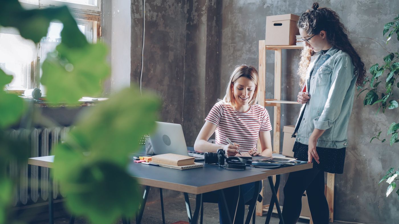 Two colleagues reviewing work together at a studio desk